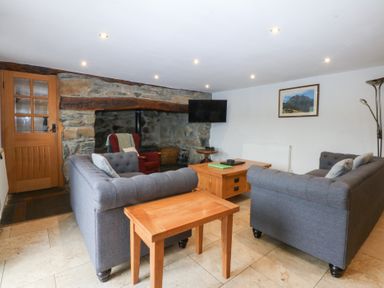 A living room with a sofa and coffee table at Ty Newydd Llanrhychwyn near Llanrwst