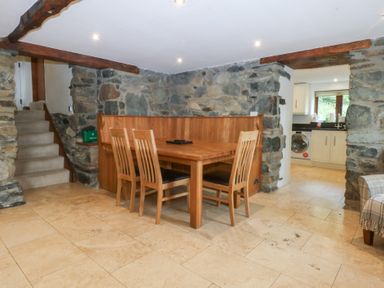 A dining area with a table and chairs at Ty Newydd Llanrhychwyn near Llanrwst