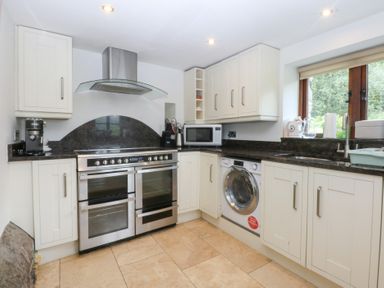 A kitchen with a stove and microwave at Ty Newydd Llanrhychwyn near Llanrwst
