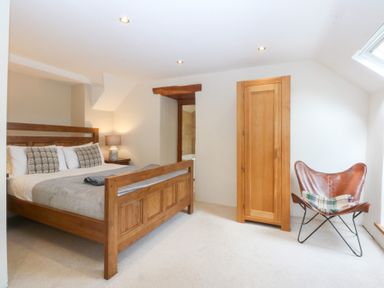 A bedroom with a wooden bed and a dresser at Ty Newydd in Llanrhychwyn near Llanrwst
