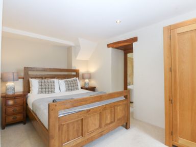 A bedroom with a wooden bed and bedside tables at Ty Newydd in Llanrhychwyn near Llanrwst