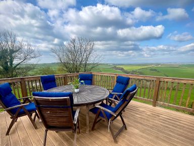A dining area with a round table and chairs at Lowena Lodge Whitsand Bay Holiday Park near Millbrook