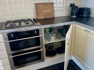 A kitchen with a gas stove, oven, and kitchenware at Lowena Lodge Whitsand Bay Holiday Park near Millbrook