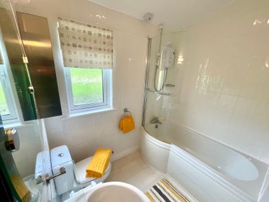 A bathroom with a bathtub, shower, and toilet at Lowena Lodge Whitsand Bay Holiday Park near Millbrook