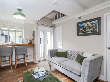 A living room with a bar counter and seating at Firefly Cottage