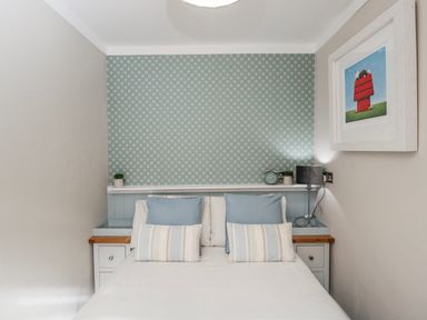 A bedroom with a bed and nightstand at Firefly Cottage