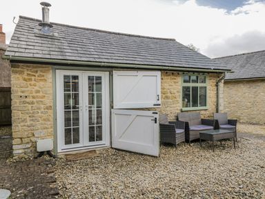 An outdoor seating area with a table and chairs at Firefly Cottage