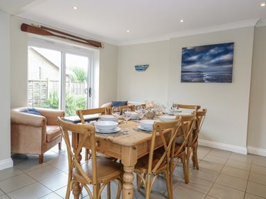 A dining room with a table set for meals at Woodlark