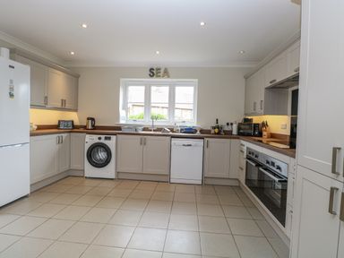 A kitchen with white cabinets and appliances at Woodlark