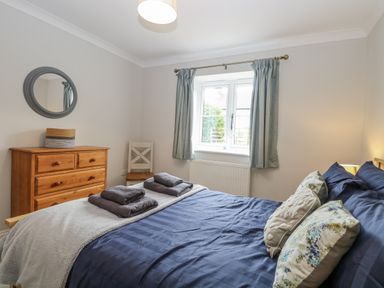 A bedroom with a bed and dresser at Woodlark