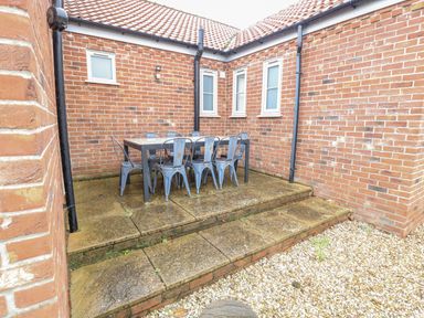 An outdoor dining area with a table and chairs at Woodlark