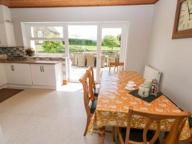 A dining room with a table and chairs at The Sycamores in Llawhaden near Narberth
