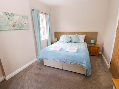 A bedroom with a bed and nightstand at The Sycamores in Llawhaden near Narberth