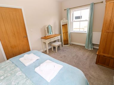 A bedroom with a bed and dressing table at The Sycamores Llawhaden near Narberth