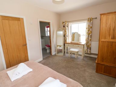 A bedroom with a bed and a dressing table at The Sycamores in Llawhaden near Narberth