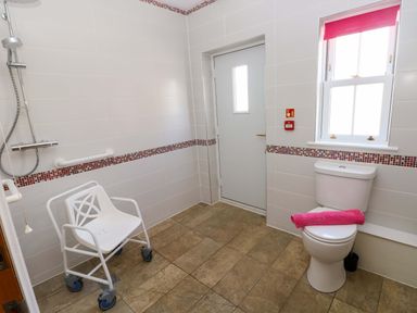 A bathroom with a shower and wheelchair at The Sycamores in Llawhaden near Narberth