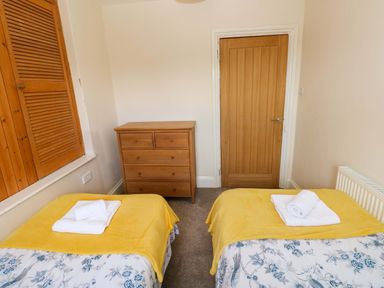 A bedroom with two beds and a dresser at The Sycamores in Llawhaden near Narberth