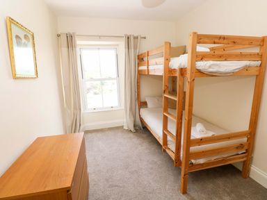 A bedroom with a bunk bed and dresser at The Sycamores Llawhaden near Narberth