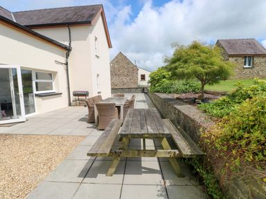 An outdoor seating area with a table and chairs at The Sycamores in Llawhaden near Narberth