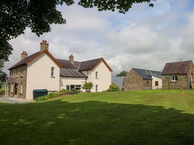 A house and garage with green grass and trees at The Sycamores in Llawhaden near Narberth