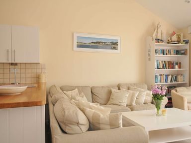 A living room with a sofa and coffee table at 9 Slipway Cottages in Rock