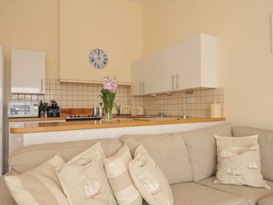 A kitchen with a sink and cabinets at 9 Slipway Cottages in Rock