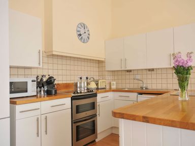 A kitchen with appliances and a vase in 9 Slipway Cottages in Rock
