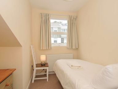 A bedroom with a bed and lamp at 9 Slipway Cottages in Rock
