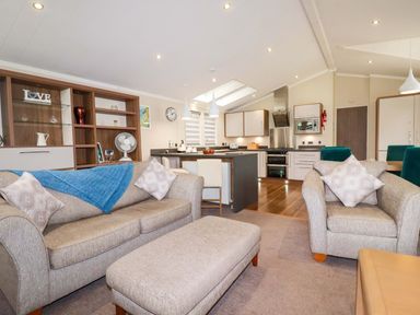 A living room with a sofa and dining area at The Maples 44 St. Austell