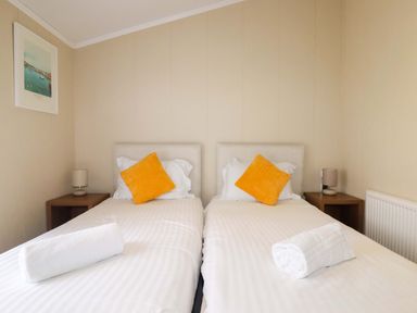 A bedroom with two single beds and a lamp at The Maples 44 St. Austell