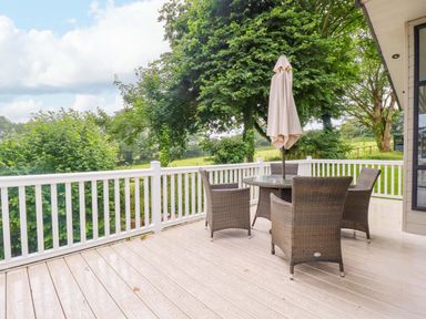 An outdoor area with a table and chairs under an umbrella at The Maples 44 St. Austell