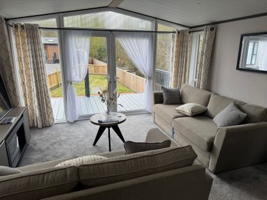 A living room with a sofa and sliding doors at Lime Tree Lodge