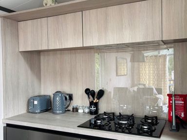 A kitchen with a gas stove and appliances at Lime Tree Lodge