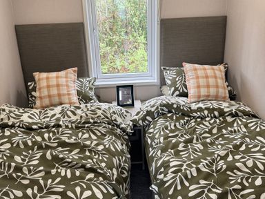 A bedroom with two beds and a window at Lime Tree Lodge