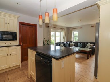 A kitchen with an island and seating area at Ash House Ballyvaughan