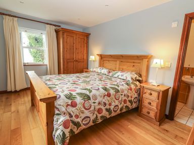 A bedroom with a bed and wardrobe at Ash House Ballyvaughan
