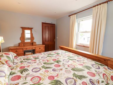 A bedroom with a bed and dresser at Ash House Ballyvaughan