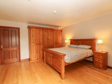 A bedroom with wooden furniture and a bed at Ash House in Ballyvaughan