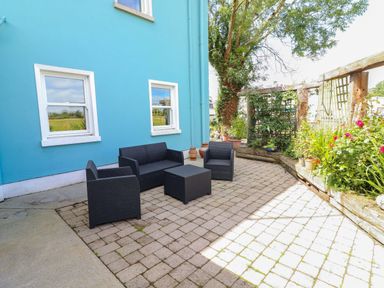An outdoor seating area with chairs and a table at Ash House in Ballyvaughan