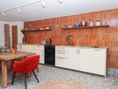 A kitchen with cabinets and dining area at Tigley Meadow Coach House in Totnes