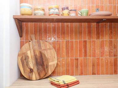 A kitchen with cups on a shelf and a cutting board at Tigley Meadow Coach House in Totnes