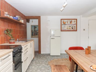 A kitchen with refrigerator, sink, stove and dining table at Tigley Meadow Coach House in Totnes
