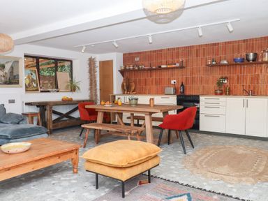 A kitchen with a dining table and chairs at Tigley Meadow Coach House in Totnes