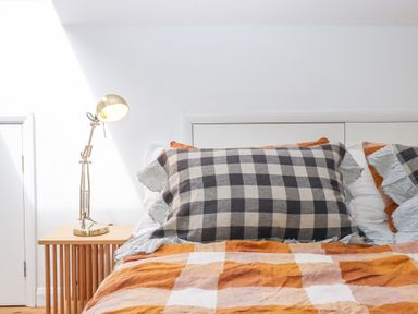 A bedroom featuring a bed with pillows and a lamp at Tigley Meadow Coach House in Totnes
