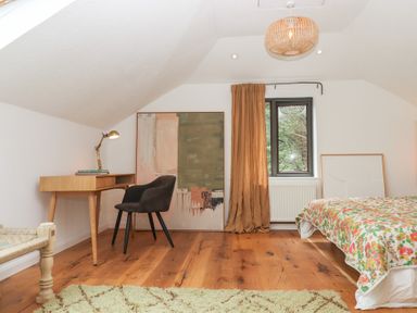 A bedroom with a desk and chair at Tigley Meadow Coach House in Totnes