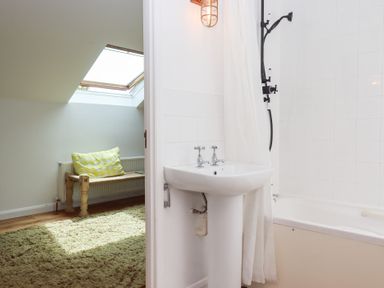 A bathroom with a wash basin and bathtub at Tigley Meadow Coach House in Totnes