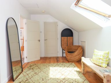 A room with a mirror, doors, chair and table at Tigley Meadow Coach House, Totnes
