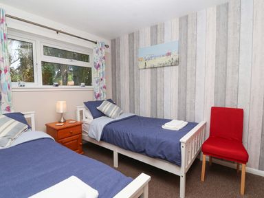 A bedroom with two beds and a nightstand at Boo’s Bungalow in Callington near Gunnislake