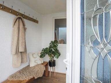 A hallway with coat hooks and a plant at Penrhos Walks Holyhead