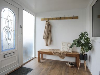 A hallway with a bench and coat hooks at Penrhos Walks in Holyhead